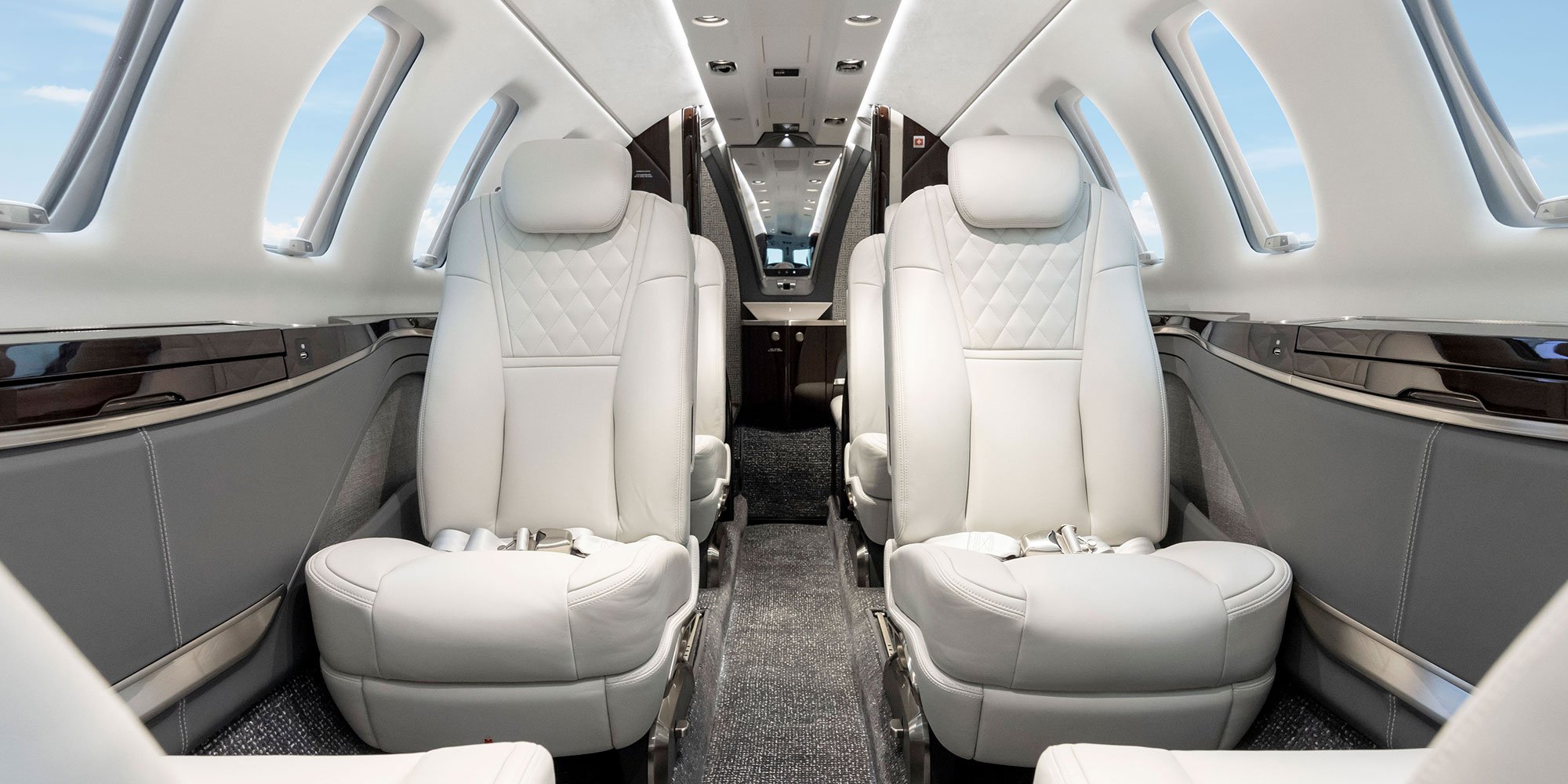 Interior cabin of a Jet OUT jet with white leather seats and panoramic windows